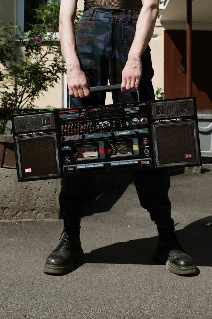 A man holds a classic vintage boombox outdoors, evoking retro vibes and nostalgia.